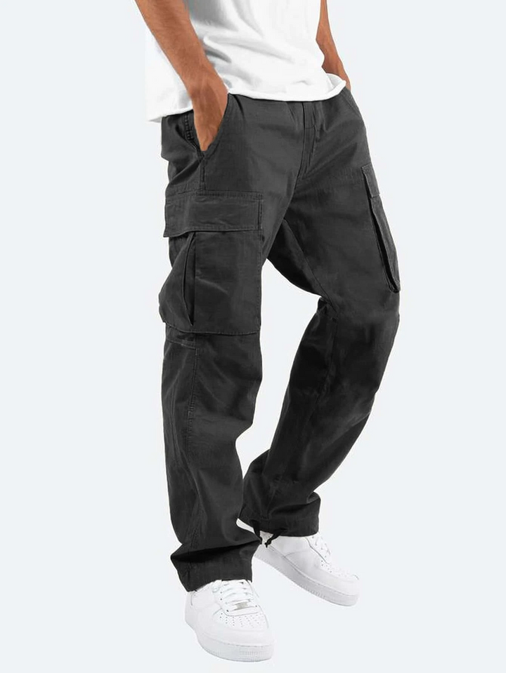 Black cargo trousers with relaxed fit and multiple utility pockets, worn with white trainers