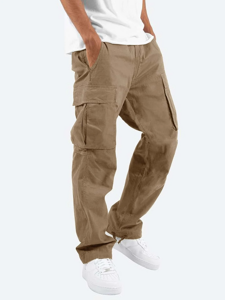 Khaki cargo trousers with roomy utility pockets and drawstring hem, paired with white trainers