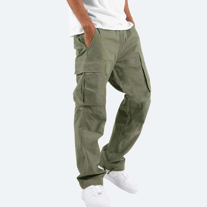 Olive green cargo trousers showing relaxed fit and side cargo pockets, worn with white trainers