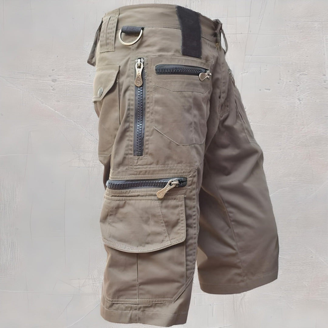 Khaki cargo shorts with layered zip pockets and metal D-ring accent