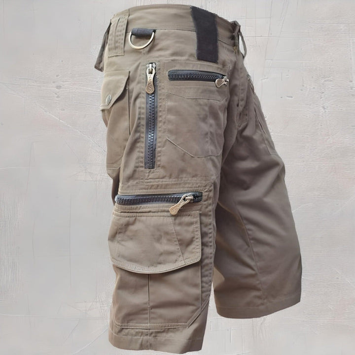 Khaki cargo shorts with layered zip pockets and metal D-ring accent