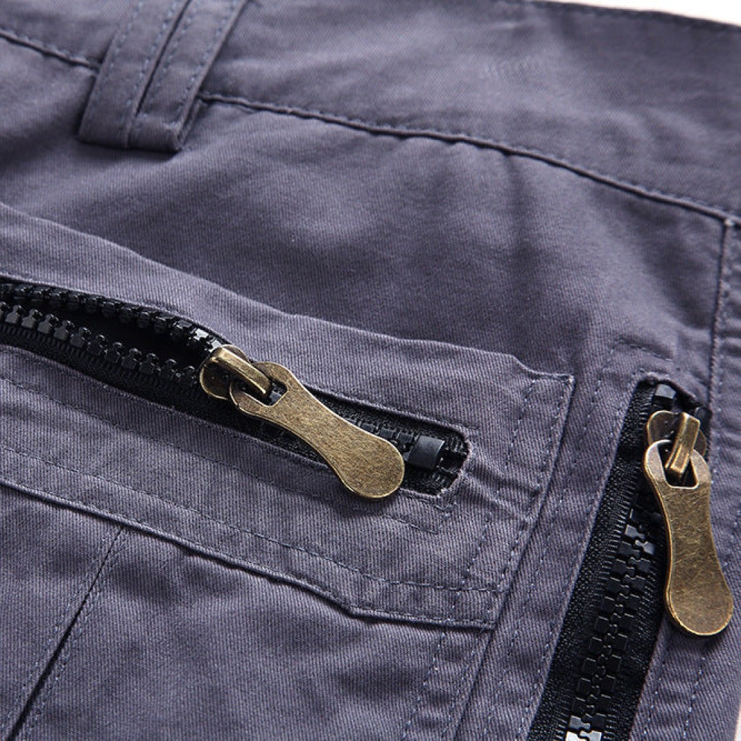 Grey cargo shorts pocket with bronze zip pull and contrast stitching
