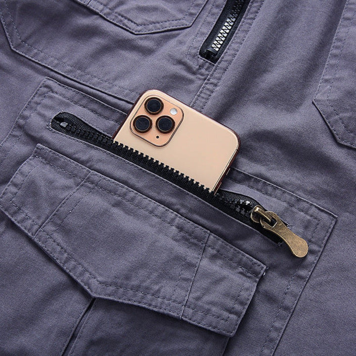 Smartphone tucked into grey cargo shorts' zip pocket, close-up detail