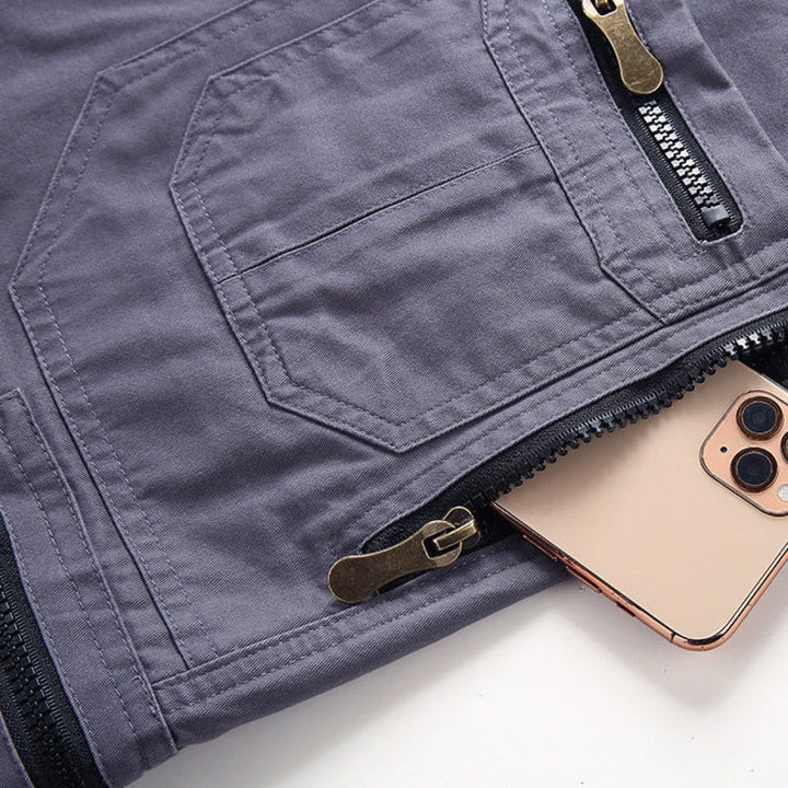 Close-up of grey cargo shorts zip pocket holding a smartphone securely