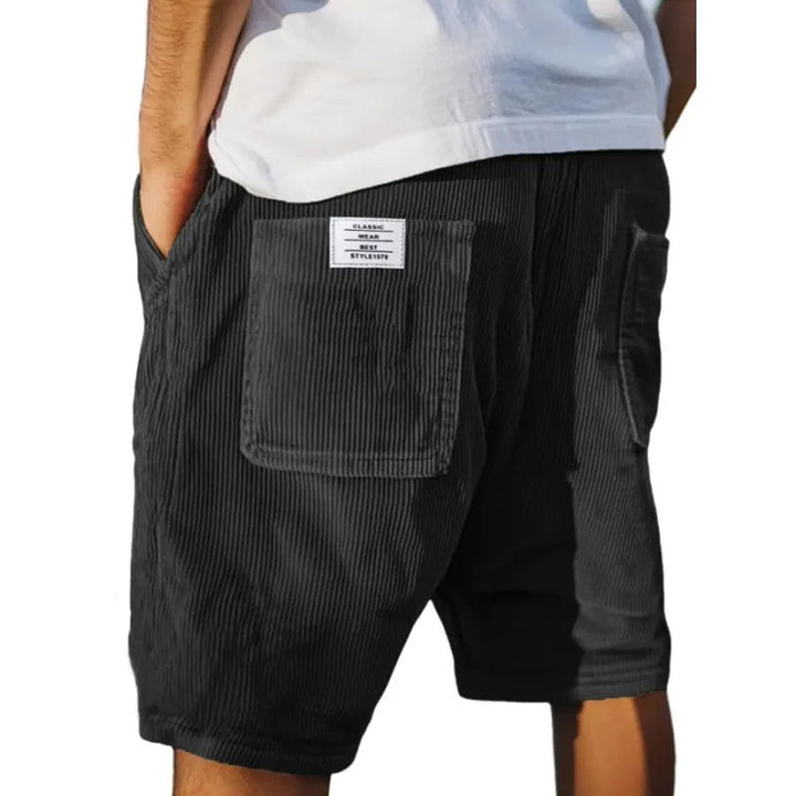 Charcoal corduroy shorts showing ribbed texture and rear patch pocket