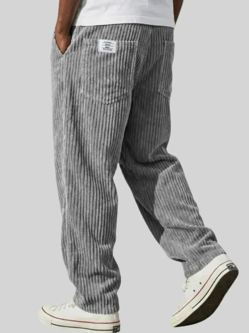 Grey ribbed corduroy trousers, relaxed fit, worn with canvas trainers