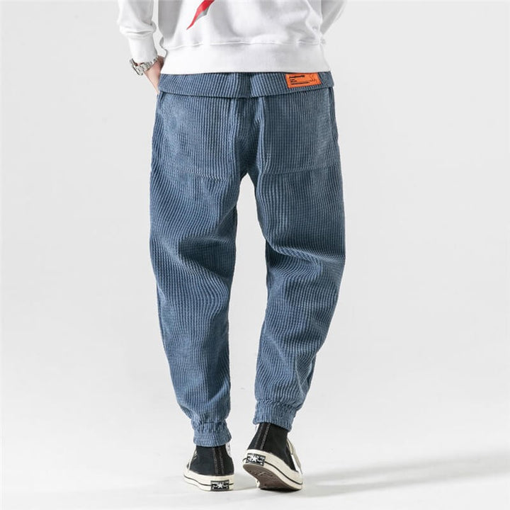 Rear view of blue corduroy joggers showing ribbed texture and elastic hem
