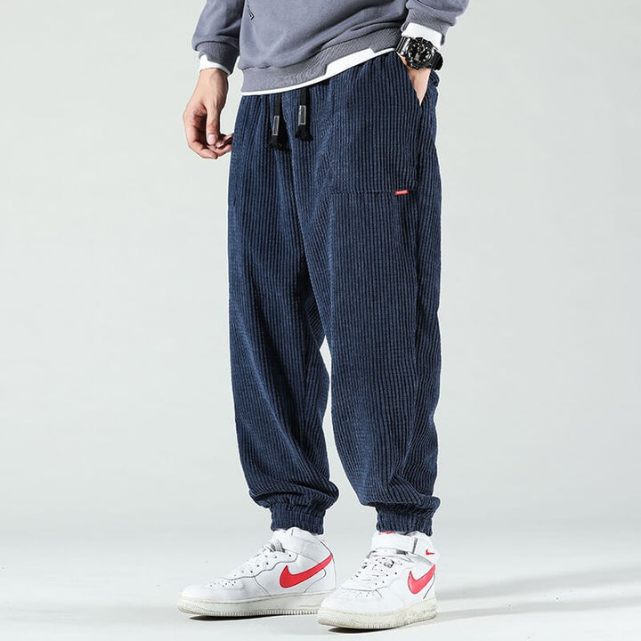 Navy corduroy joggers styled with white trainers and drawstring waistband