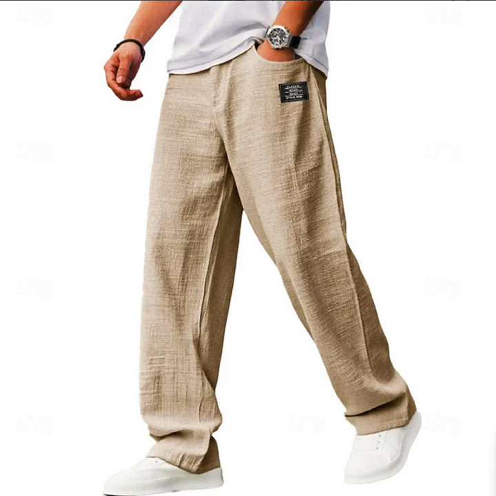Beige linen-blend loose-fit trousers worn with a white t-shirt and trainers