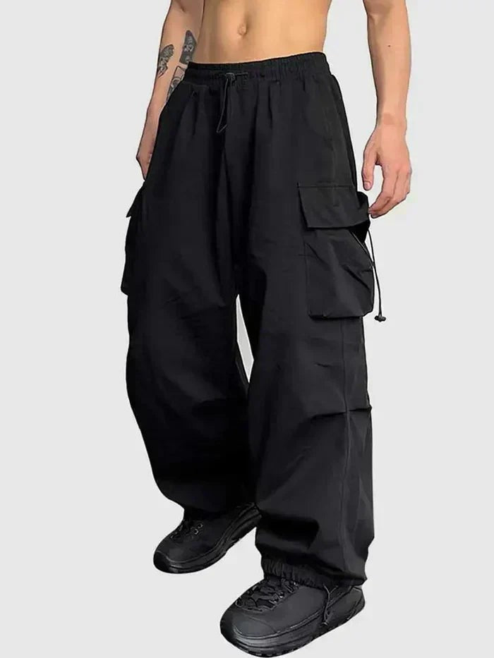 Black wide-leg cargo trousers with drawstring waist and flap pockets, worn on model