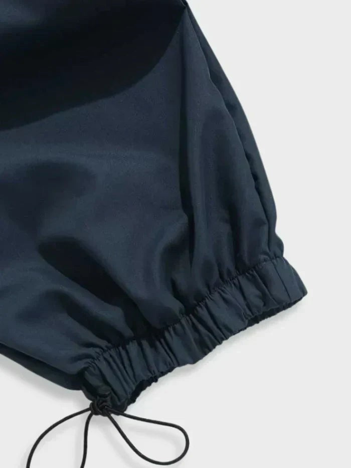 Close-up of navy cargo trousers' cuff showing elasticated hem and toggle tie