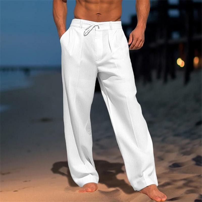 White wide-leg men's trousers with drawstring waist, styled on a sandy beach