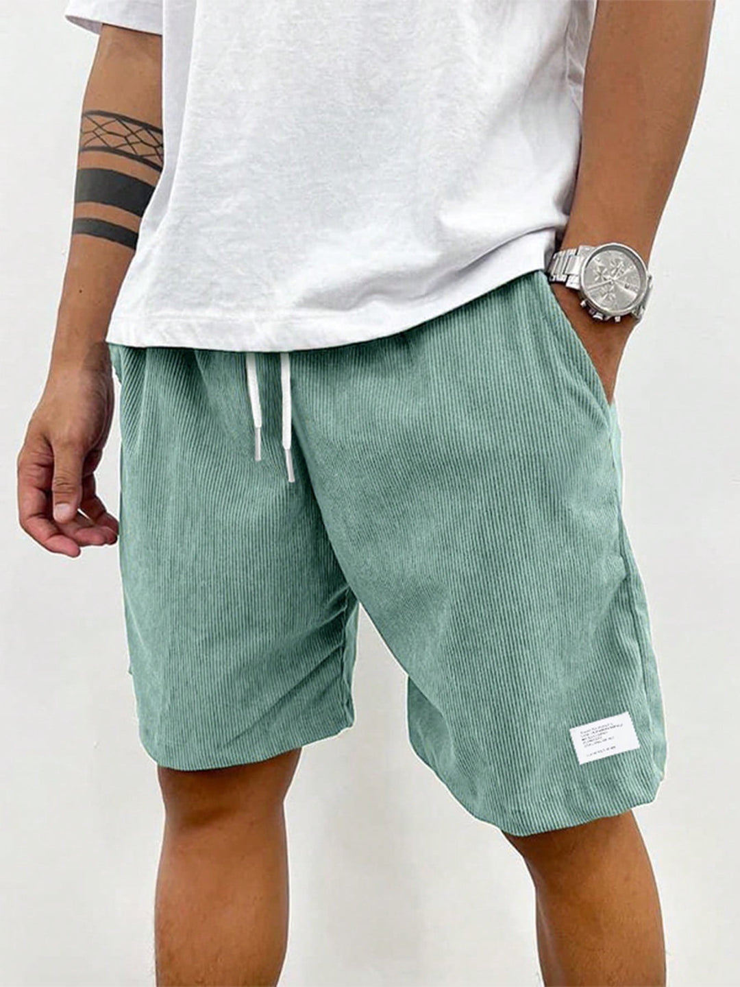 Sage green corduroy casual shorts worn with white oversized t-shirt