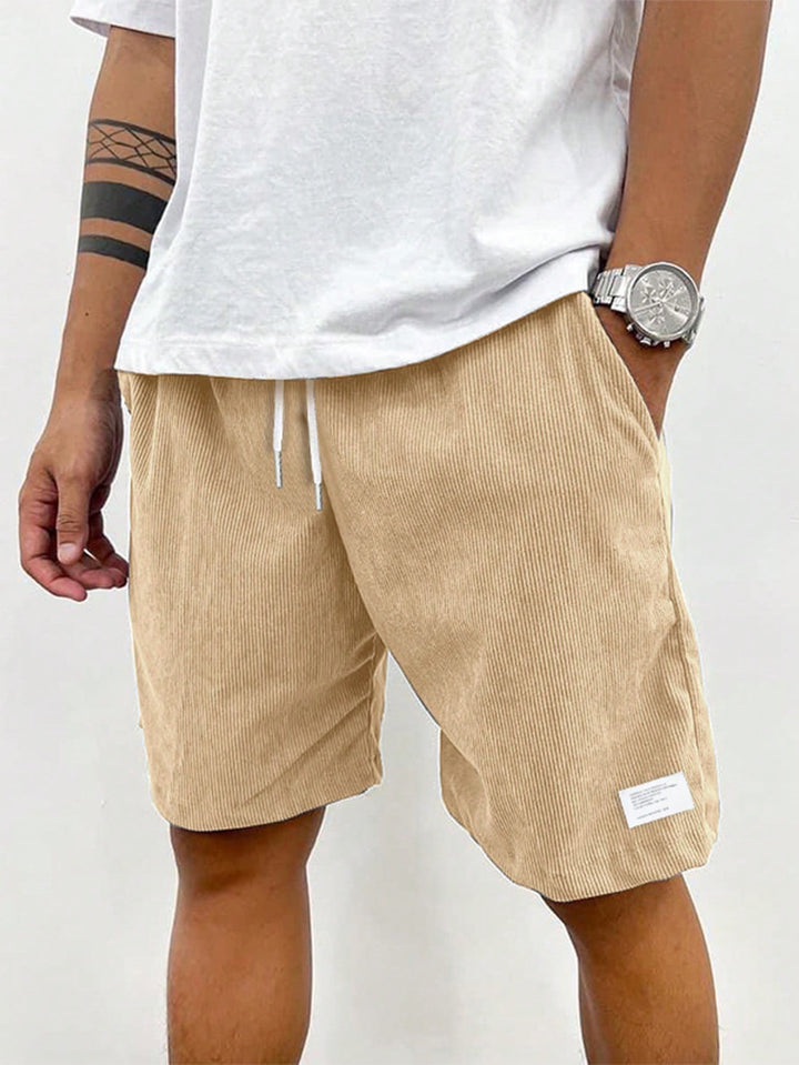 Beige ribbed corduroy shorts with drawstring waist, paired with white t-shirt