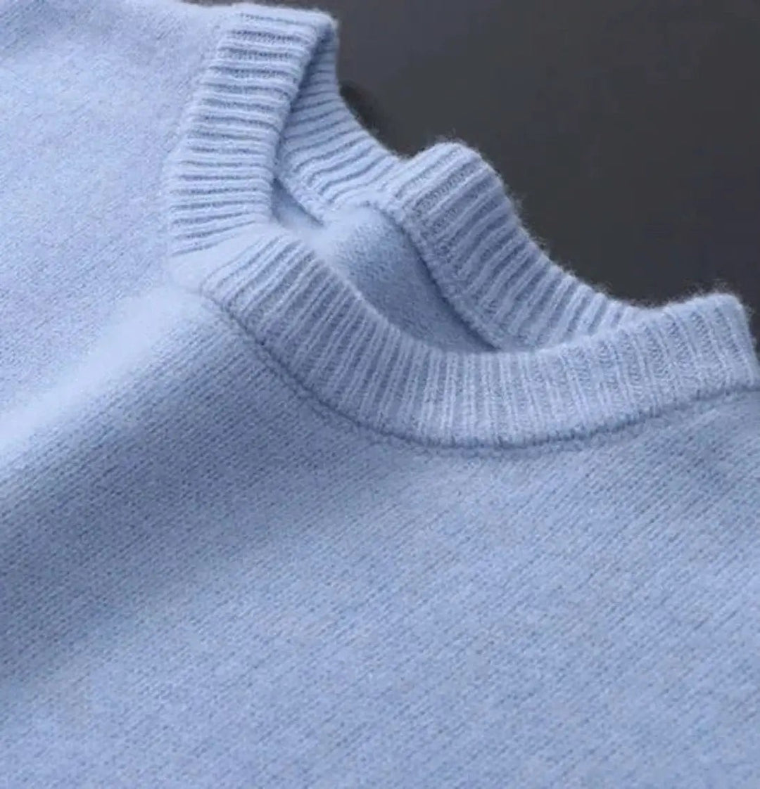 Close-up of ribbed crew neckline on pale blue knit jumper