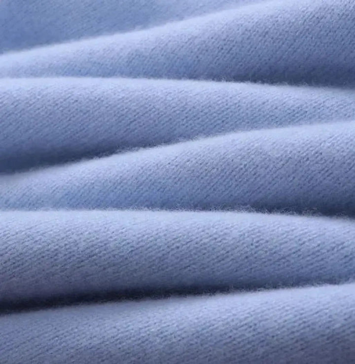 Close-up of soft knitted fabric texture on pale blue jumper