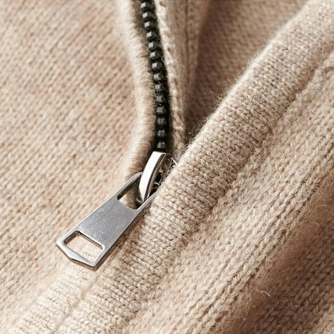 Close-up of zip pull detail on beige ribbed knit jumper