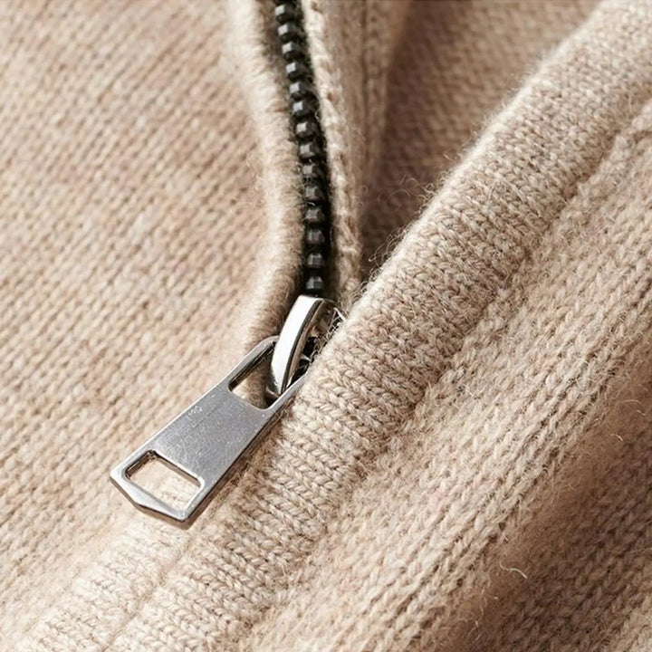 Close-up of zip pull detail on beige ribbed knit jumper