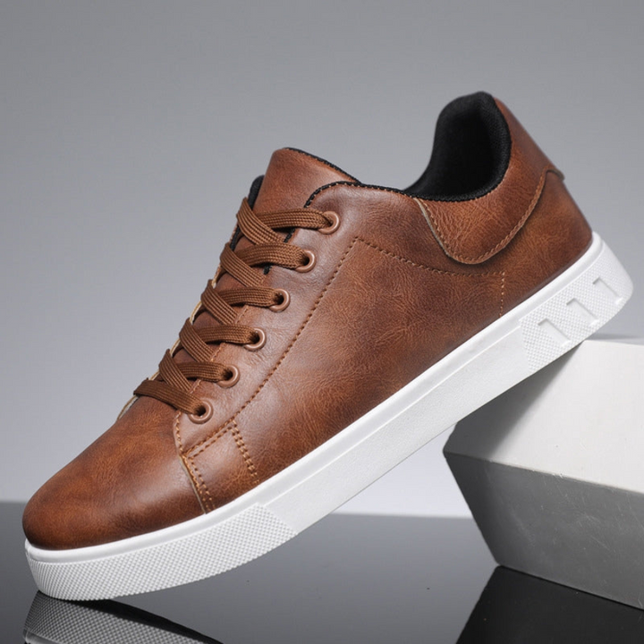 Tan brown leather lace-up trainers with white sole, shown side-on angle