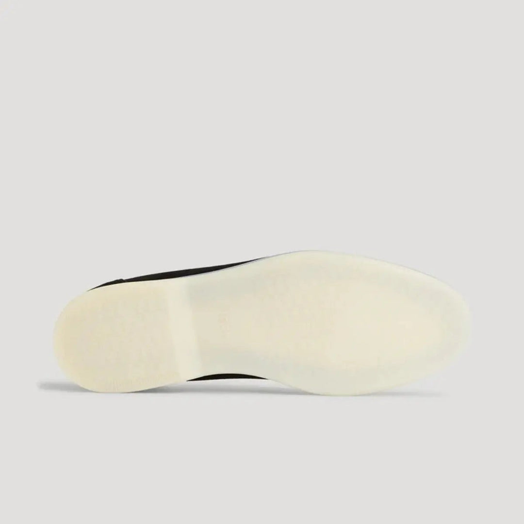 Side profile of white flatform sole on black suede loafer
