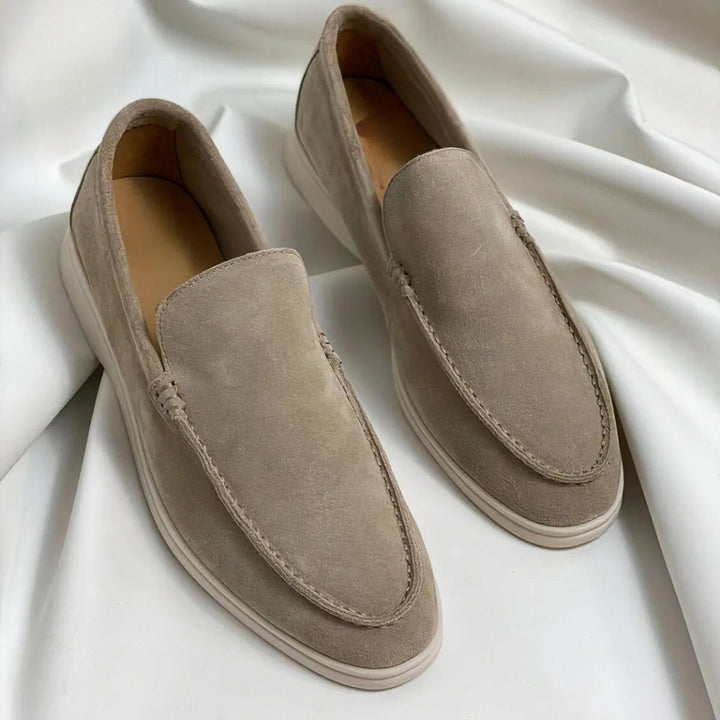 Taupe suede loafers featuring stitched apron toe and white sole