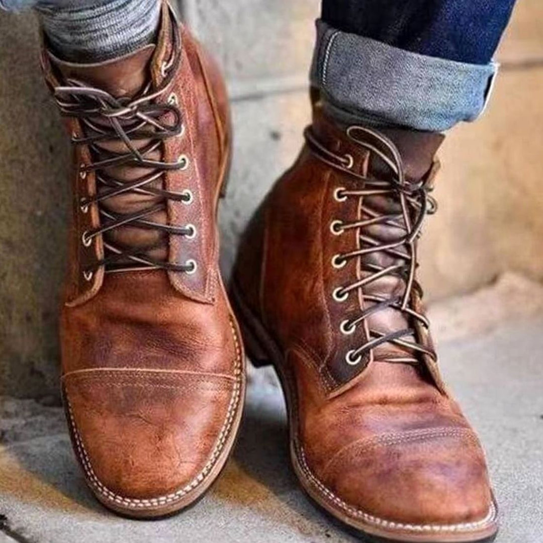 Tan leather lace-up boots worn with turned-up denim jeans