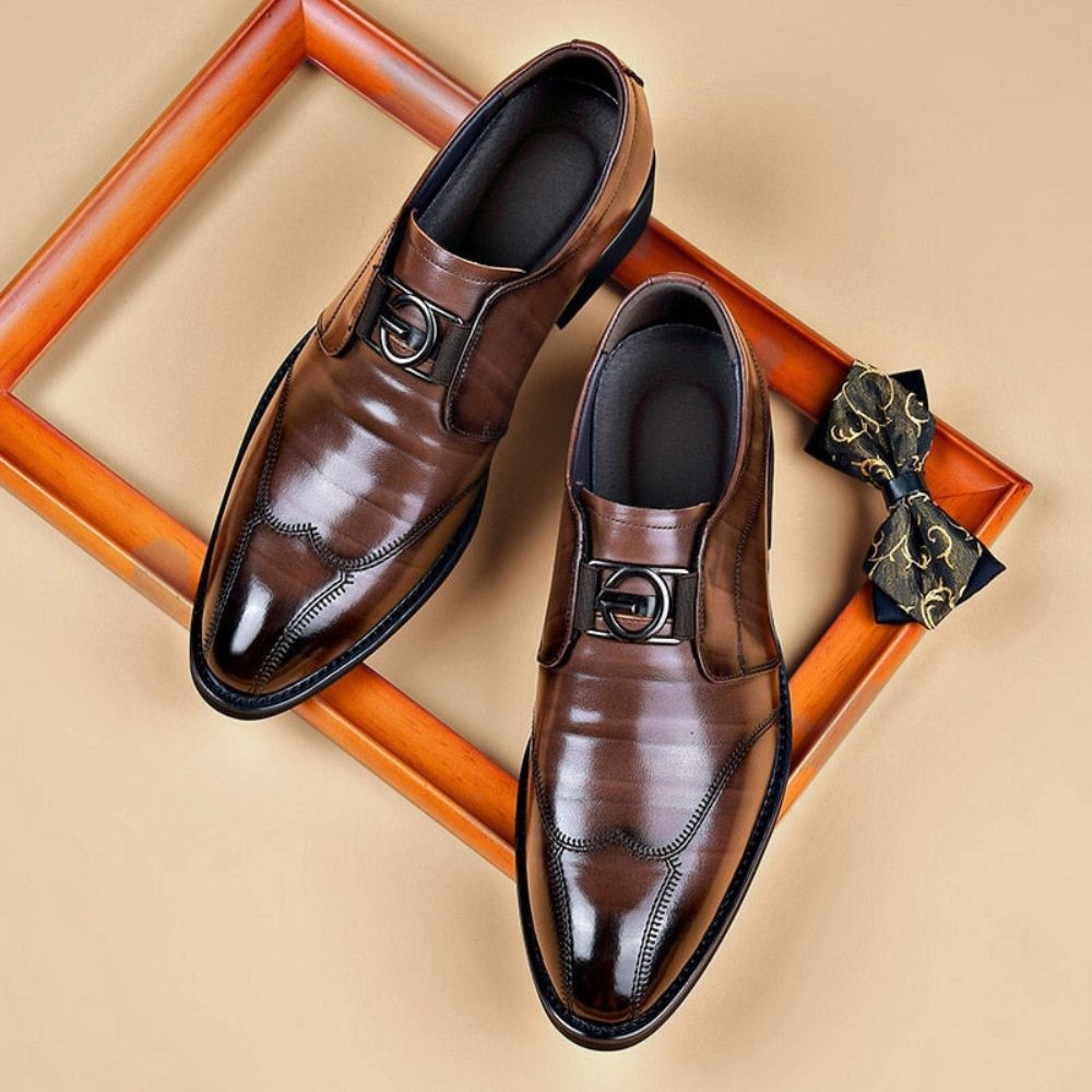 Brown pointed-toe monk strap shoes displayed with matching bow tie