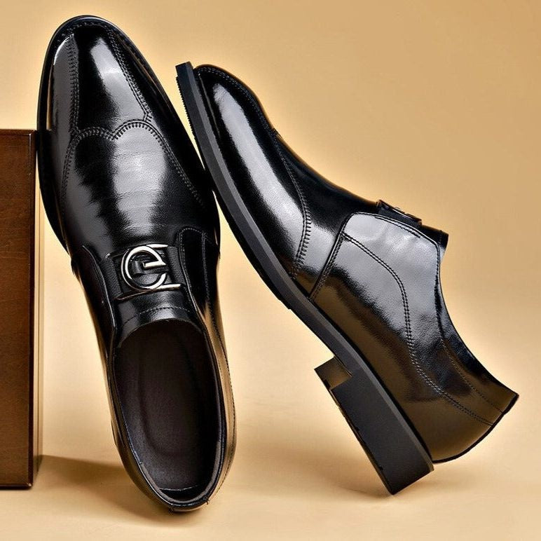 Pair of black leather monk strap shoes resting against gift box