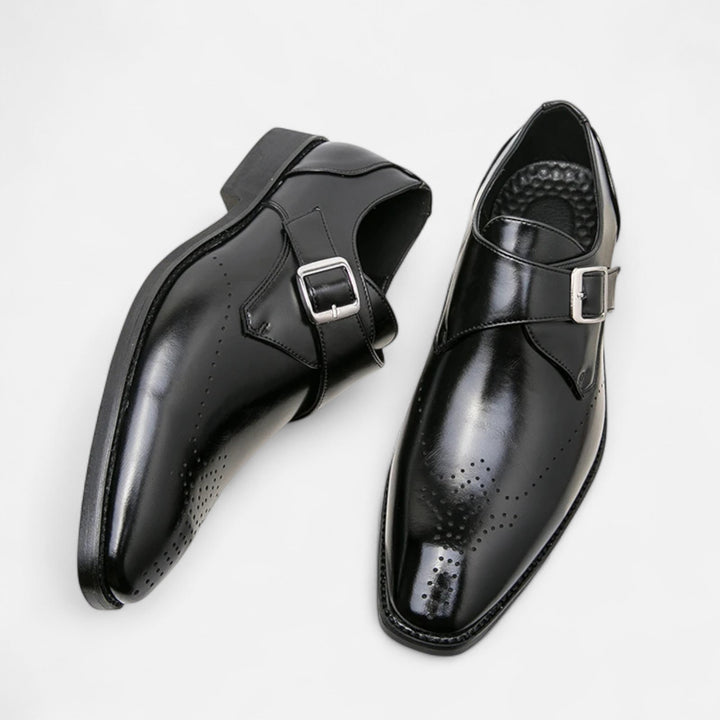 Black leather single monk strap shoes with buckle and brogue detailing, top view