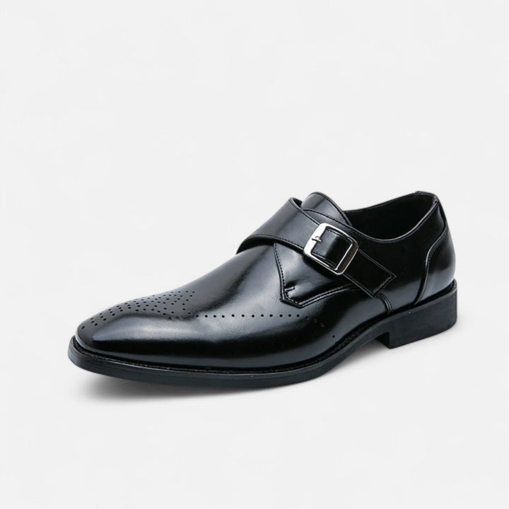 Black leather brogue monk strap shoe shown at an angle against a plain background