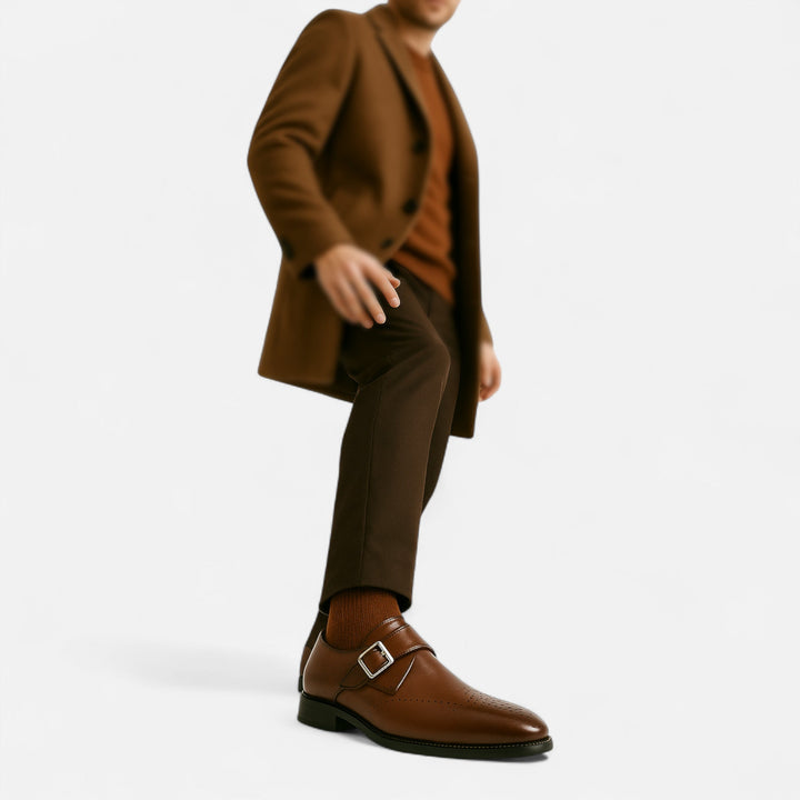 Close-up of a man's leg wearing tan brogue monk strap dress shoe