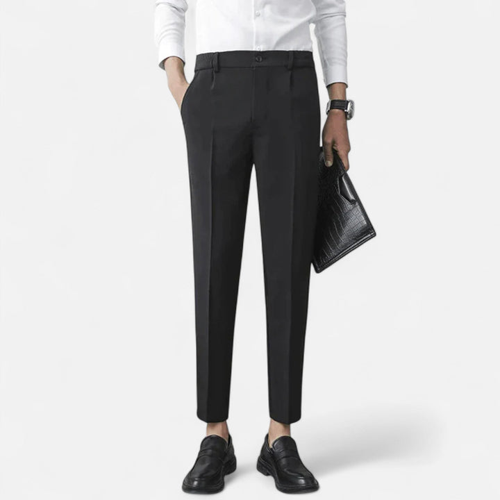 Black slim-fit tailored trousers worn with white shirt and leather clutch