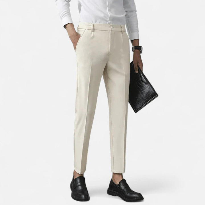 Cream slim-fit ankle-length trousers styled with white shirt and black loafers