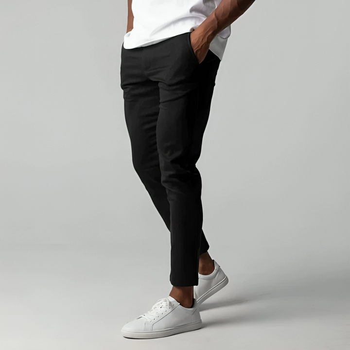 Black slim-fit chinos worn with white trainers, tapered ankle length