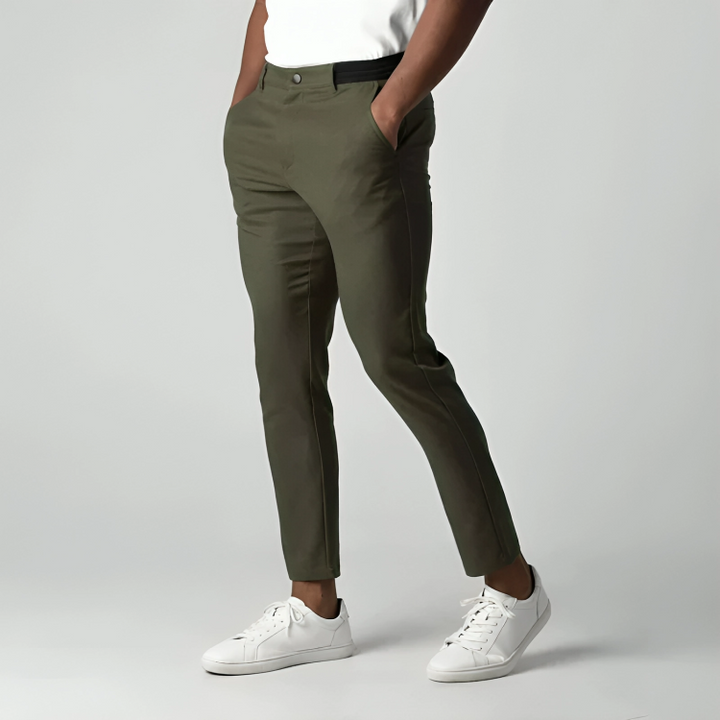 Olive green tapered chinos with hands in pockets, slim silhouette