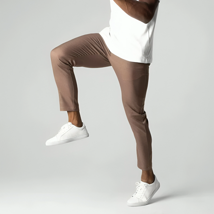 Brown tapered trousers in motion, showing stretch fabric and slim fit