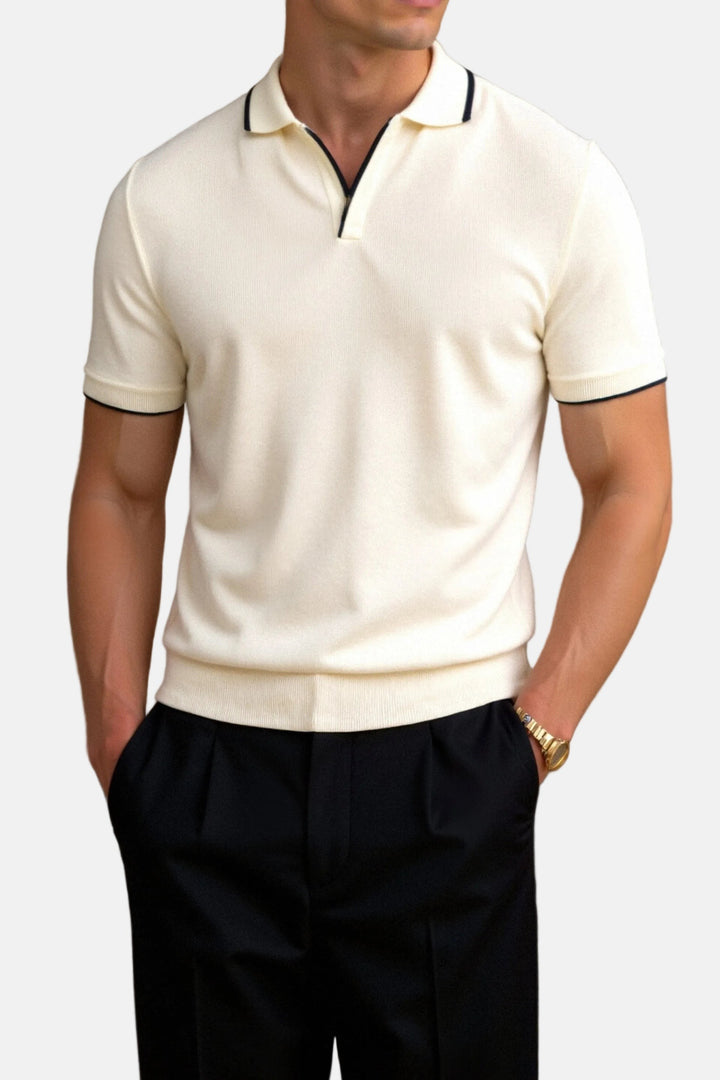 Cream knitted polo shirt with navy tipped collar, worn with tailored black trousers