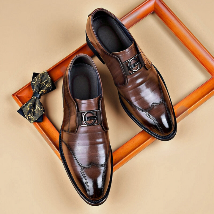 Brown leather slip-on dress shoes with buckle accent and stitched detailing