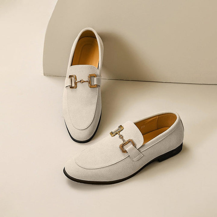 Cream suede loafers featuring gold horsebit trim, paired sole to sole