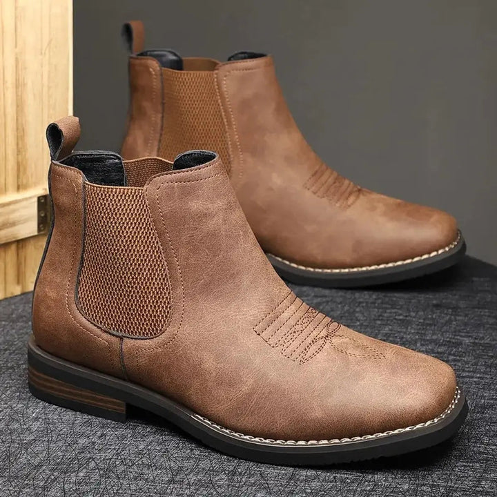 Brown leather Chelsea boots paired together showing stitched western detail