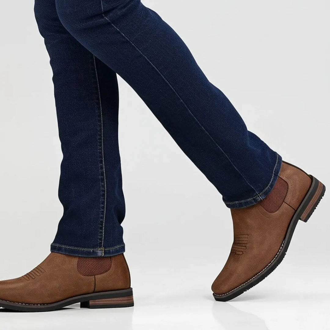 Close-up of tan Chelsea ankle boot on foot, stitched toe design