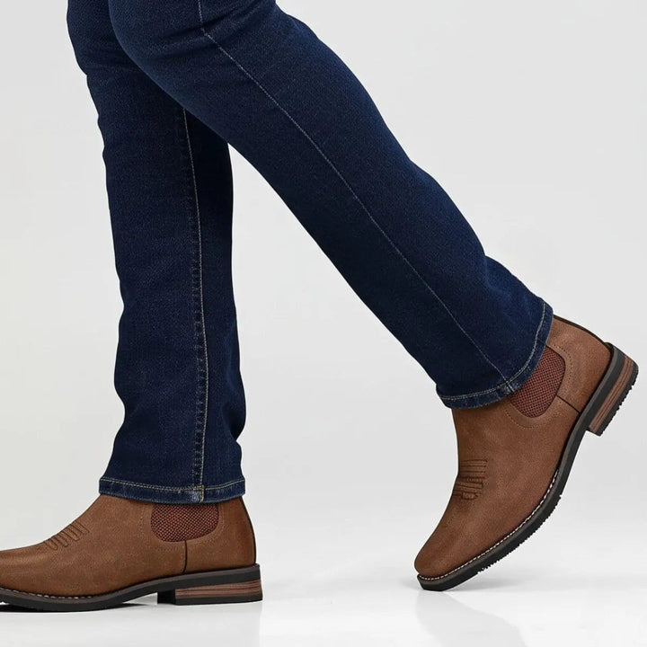 Close-up of tan Chelsea ankle boot on foot, stitched toe design