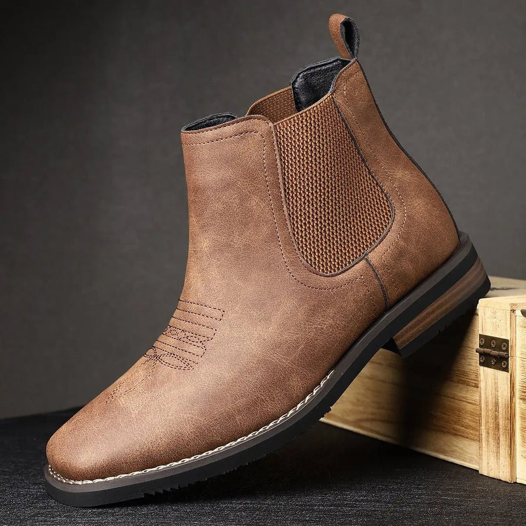 Tan Chelsea ankle boot resting against wooden crate, side profile view