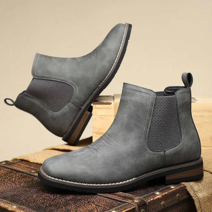 Grey Chelsea boots shown from above, one tilted to reveal sole
