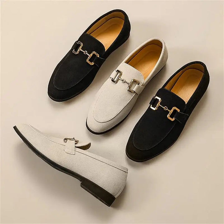 Black and ivory suede loafers with gold trim, arranged in a group display