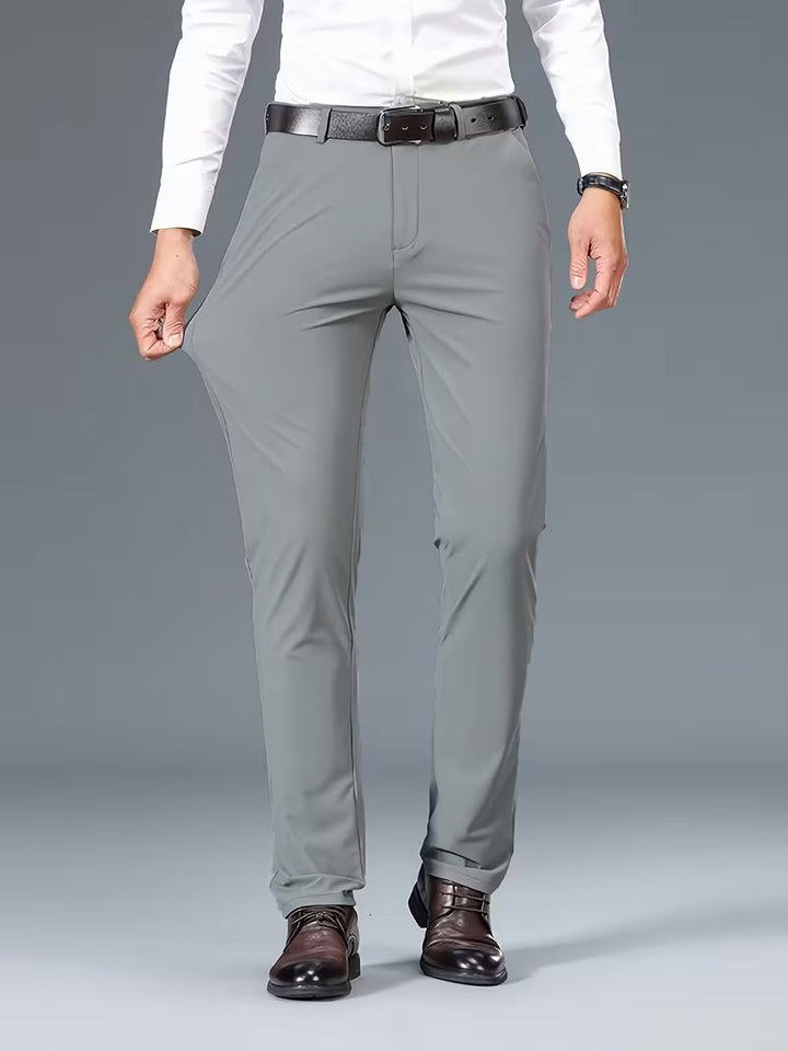 Grey stretch trousers worn full-length with leather belt and brown shoes