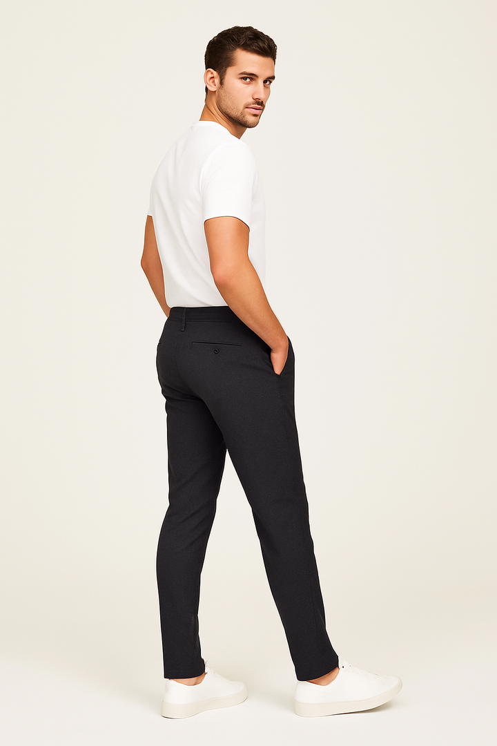 Black tailored slim fit trousers shown from behind with cream trainers