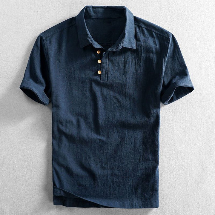 Navy linen short sleeve polo shirt with wooden button placket, laid flat