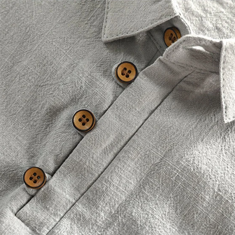 Close-up of wooden buttons and collar stitching on grey linen polo shirt