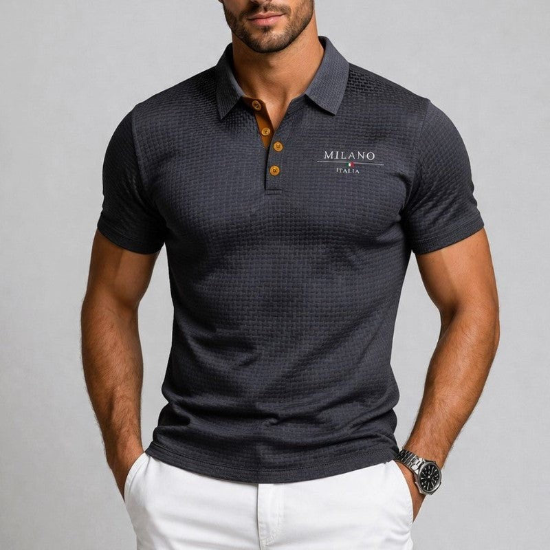 Close-up of charcoal polo shirt collar with tan button placket and logo